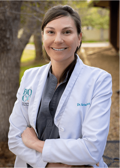 Dr.Patt standing outdoors with arms crossed, surrounded by trees.